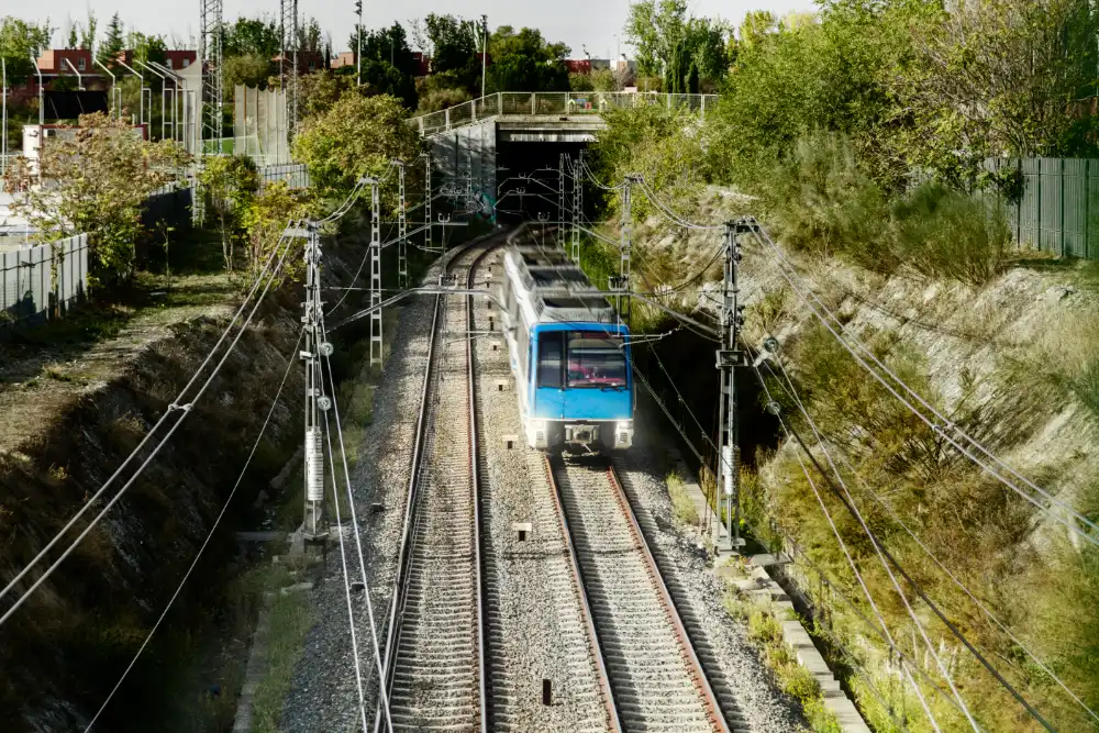 Electric train leaving a tunnel under overhead catenary wires