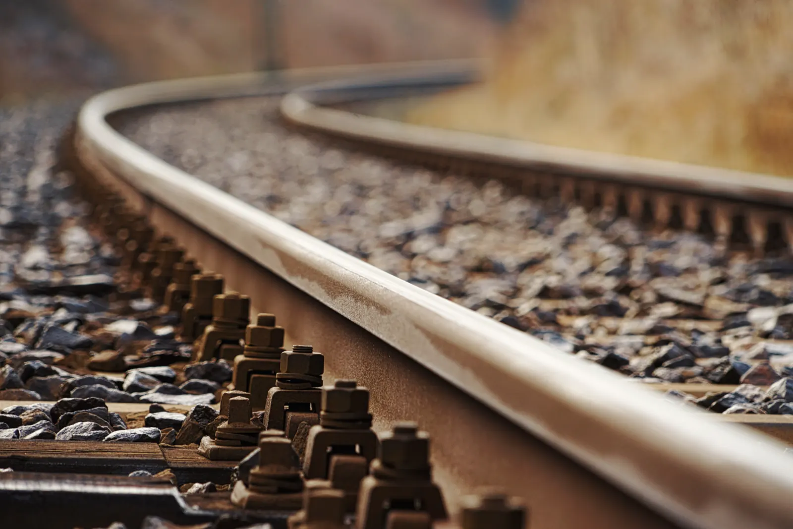 Close-up of a curved railway track with rail fastenings